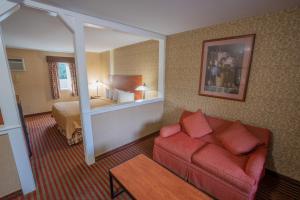 伯恩全季汽车旅馆的酒店客房配有红色的沙发和床。