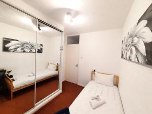 伦敦London North Downs rooms的小房间设有镜子和一张床