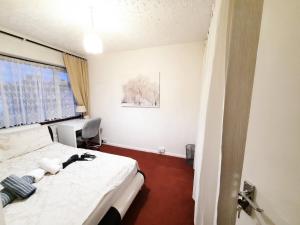 伦敦London North Downs rooms的一间卧室配有一张床和一张书桌