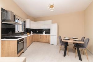 普莱诺斯Spartakos Luxury Villa 6的带桌椅的厨房以及带白色家电的厨房。