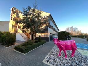 利雪利雪基里亚德酒店的一座大楼前的粉红色牛雕像