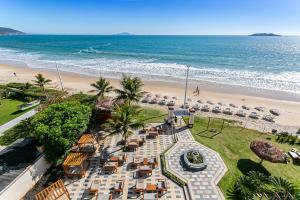 弗洛里亚诺波利斯Ingleses Palace Hotel的享有海滩的空中景致,配有椅子和海洋