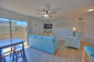 格尔夫海岸Living the Dream 2 Bedroom Ocean View Cozy Condo的客厅配有蓝色的沙发和桌子