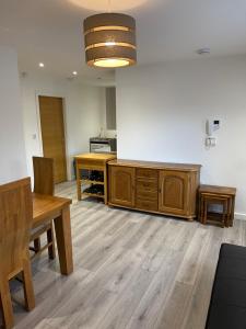 弗姆比Lovely 4 bed apartment in centre of Formby的厨房配有桌子和木制橱柜。