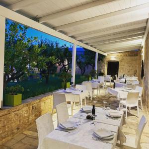 奥斯图尼马塞里亚瓦伦特农家乐的一间设有白色桌子和白色椅子的餐厅