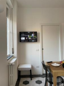 米兰La Marina di Milano - Pier Lombardo的一间房间,墙上设有一张桌子和一台电视机