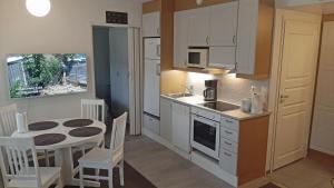 塔库沃里Apartments Golf的带小桌子的厨房和带白色橱柜的厨房