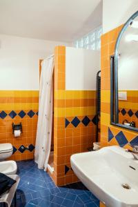 马罗内Un posto davvero unico!的浴室铺有橙色和蓝色瓷砖,配有水槽
