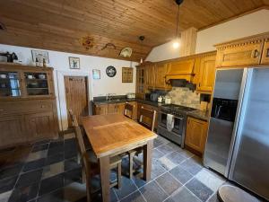 多尼戈尔John the mills cottage spaHot tub private beach的厨房配有木桌和不锈钢冰箱。