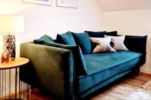 卡尔斯鲁厄Stilvolle Maisonette Wohnung的客厅配有一张蓝色的沙发,配有一张桌子