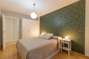 格拉纳达Capricho en el centro de Granada.的一间卧室设有一张床和绿色的墙壁