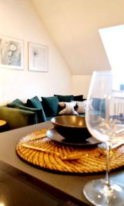 卡尔斯鲁厄Stilvolle Maisonette Wohnung的桌上放着碗和一杯葡萄酒
