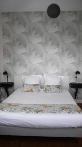 阿旺桥Maison Castel Braz的一张带两个枕头和墙壁的白色床