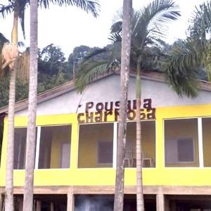 苏佩拉古伊POUSADA CHARMOSA的一座黄色和白色的建筑,前面有棕榈树