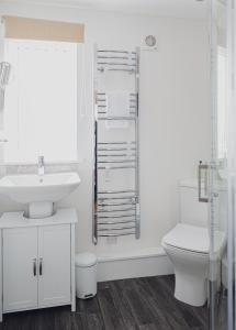 斯佩河畔格兰敦Courtyard Bothy的白色的浴室设有水槽和卫生间。