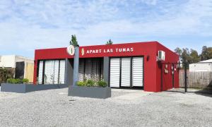 卡梅隆Apart Las Tunas Carmelo的一座红色的建筑,上面有读弧形旋转的标志