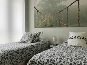 潘普洛纳Apartamento Singular Deluxe的一间卧室设有两张床和吊桥