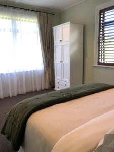 KahuranakiRiver View Cottage的一间卧室配有床和带窗帘的窗户