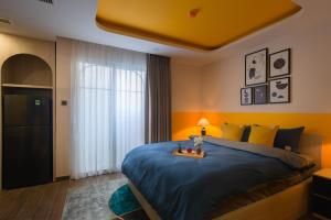 芽庄Pavillon Garden Hotel & Spa Nha Trang的一间卧室配有一张带蓝色棉被的大床