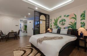 芽庄Pavillon Garden Hotel & Spa Nha Trang的一间带大床的卧室和一间餐厅