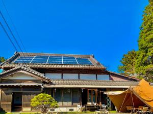 Minato和心村ー古民家とグランピングと自然森山川海的屋顶上设有太阳能电池板的房子