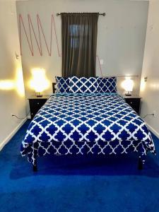 长岛市3 bedrooms 1 bath APT, 10 min to Manhattan!的一间卧室配有一张蓝色的床和两盏灯。