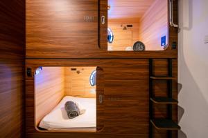 哥打京那巴鲁Jpod Capsule Hotel的客房设有两张双层床和梯子