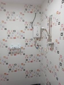 瓜埠Impian Stay 0.1 Townhouse with 3 bedrooms.的浴室的墙壁上铺有许多瓷砖。