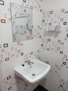 瓜埠Impian Stay 0.1 Townhouse with 3 bedrooms.的白色的浴室设有水槽和镜子