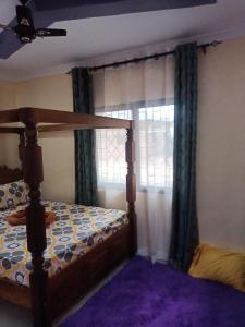 蒙巴萨Coasterian Apartment的一间卧室配有床和带窗帘的窗户