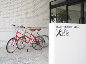 三岛市Hotel Gee Haive的停放在大楼前的两辆自行车