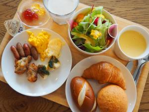 三岛市Hotel Gee Haive的餐桌,盘子上放着食物,沙拉和面包