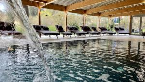 拉波斯安德萨亚列布尼兹穆尔餐厅-酒店的一个带椅子的游泳池以及一个喷泉