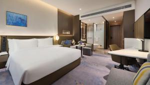 武汉武汉开发区保和皇冠假日酒店的酒店客房设有一张白色大床和一张书桌
