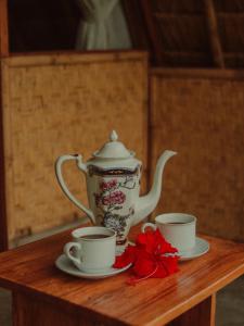 姆杜克Da'kayu Glamping的木桌边的茶壶和两个杯子