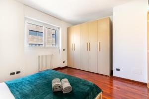 米兰Appartamento Bicocca - Affitti Brevi Italia的一间卧室配有一张床和两双鞋