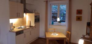 奥登塔尔Ferienwohnung Koch的厨房配有桌子、水槽和窗户