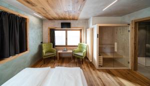 利维尼奥拉瑞斯酒店的一间卧室配有两把椅子、一张床和窗户