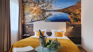 梅灵Hotel "Zum Moseltal"的卧室配有一张黄色的床,墙上挂着一幅画