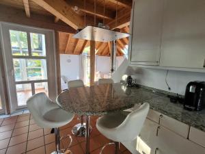 巴林根Architektenhaus Albblick的厨房配有桌子和一些白色的椅子