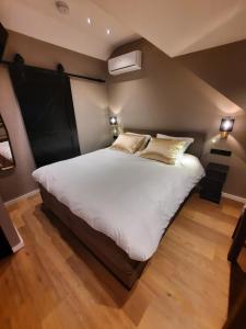 GuelleB&B de Maaskei的卧室配有一张带白色床单和枕头的大床。