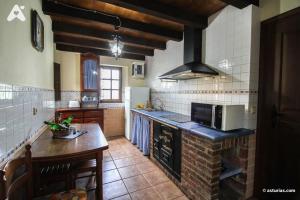 VillarmilCasa Rural La Cuesta的一间带柜台和炉灶的厨房 顶部烤箱