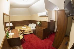 拉多姆Hotel Poniatowski的小房间设有一张床和一张书桌