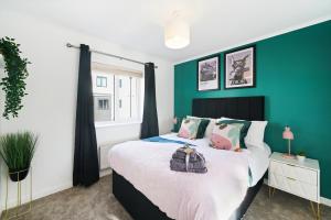 伍尔弗汉普顿Ideal 3 bed House in Wolverhampton - Parking的一间卧室设有绿色墙壁和一张床