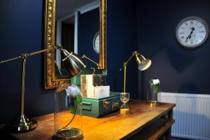 雷特福德The Herbalist Rooms的一张带两盏灯、镜子和时钟的桌子