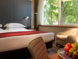 伦敦皇家花园酒店的酒店客房设有一张床和一张带果盘的桌子。