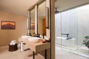 塞拉莱Alila Hinu Bay Salalah Mirbat的浴室配有2个盥洗盆和1个浴缸。