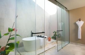 塞拉莱Alila Hinu Bay Salalah Mirbat的带浴缸和玻璃淋浴间的浴室。