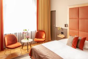 柏林库弗斯坦达姆大街厄尔巴酒店 - 钱伯斯设计的一间卧室配有一张床、两把椅子和一张桌子