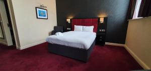 坎伯恩约翰弗朗西斯巴塞特韦瑟斯彭酒店的一间卧室配有一张大床和红色床头板